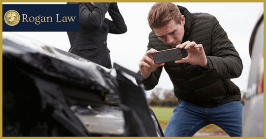 man taking photos of car damage after accident